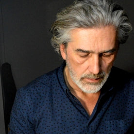 Jeweller working on a craft project with tools and materials on a table.